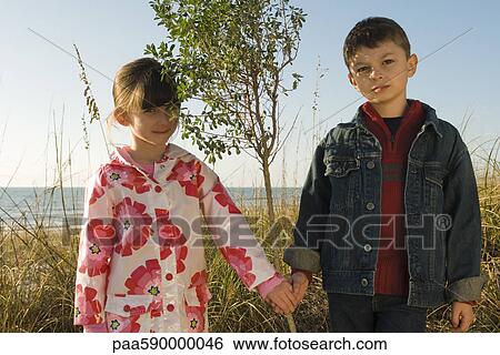 Young boy and girl holding hands, portrait View Large Photo Image Stock Photograph - Young boy and girl holding hands, portrait. Fotosearch