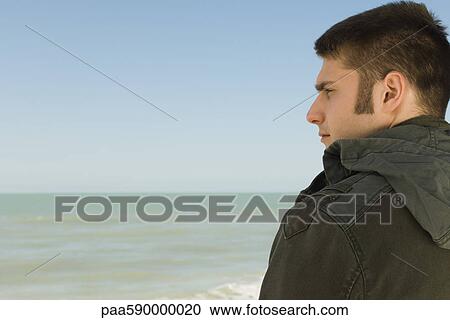 Young man at beach contemplatively looking at view View Large Photo Image Stock Image - Young man at beach contemplatively looking at view. Fotosearch