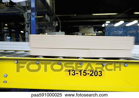 Stock Photography - Cardboard box moving along conveyor belt in carpet tile factory. Fotosearch
