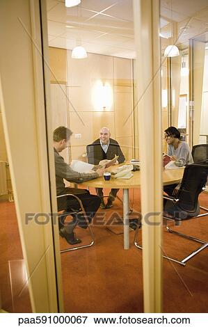 Stock Photo - Colleagues discussing carpet samples in meeting room. Fotosearch
