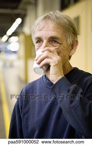 Factory worker drinking cup of coffee View Large Photo Image Stock Image - Factory worker drinking cup of coffee. Fotosearch