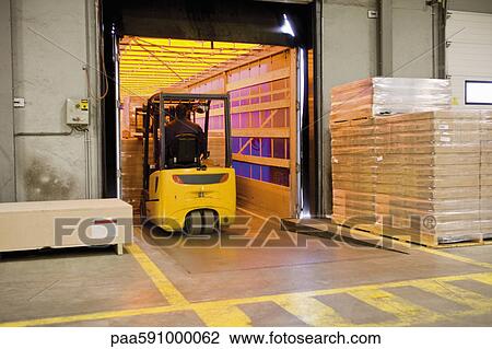 Forklift operator loading wrapped pallets of cardboard boxes onto trailer in warehouse View Large Photo Image Stock Image - Forklift operator loading wrapped pallets of cardboard boxes onto trailer in warehouse. Fotosearch