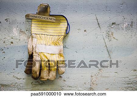 Protective work gloves held up by a binder clip on wall View Large Photo Image Stock Image - Protective work gloves held up by a binder clip on wall. Fotosearch