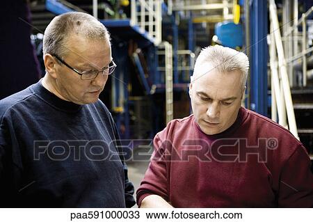 Textile workers having a discussion in factory View Large Photo Image Stock Image - Textile workers having a discussion in factory. Fotosearch