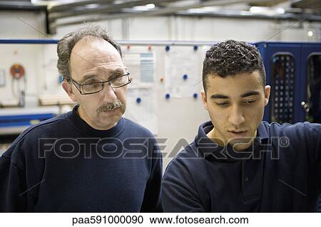 Stock Image - Textile workers talking in factory. Fotosearch