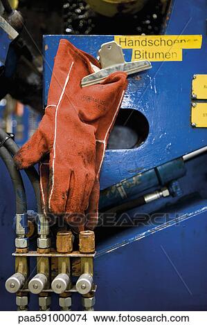 Work gloves stained with bitumen hanging on machine in carpet tile factory View Large Photo Image Picture - Work gloves stained with bitumen hanging on machine in carpet tile factory. Fotosearch