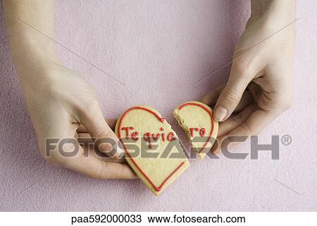 Holding broken heart-shaped cookie View Large Photo Image Stock Image - Holding broken heart-shaped cookie. Fotosearch