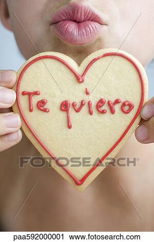 Woman puckering lips, holding up heart-shaped cookie View Large Photo Image Stock Image - Woman puckering lips, holding up heart-shaped cookie. Fotosearch