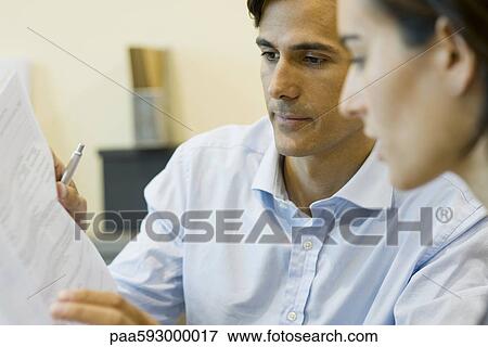 Businessman reviewing contract with client View Large Photo Image Stock Photo - Businessman reviewing contract with client. Fotosearch