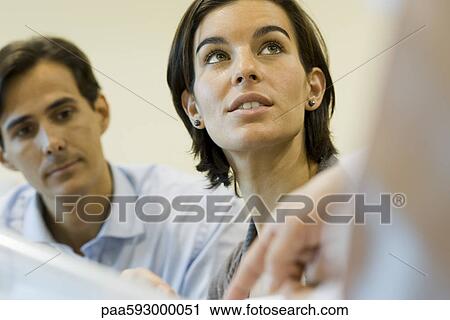 Businesswoman listening as colleague explains document, cropped View Large Photo Image Stock Image - Businesswoman listening as colleague explains document, cropped. Fotosearch