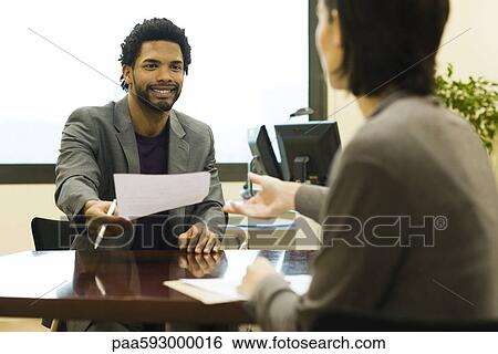 Executive handing document to colleague View Large Photo Image Stock Photograph - Executive handing document to colleague. Fotosearch