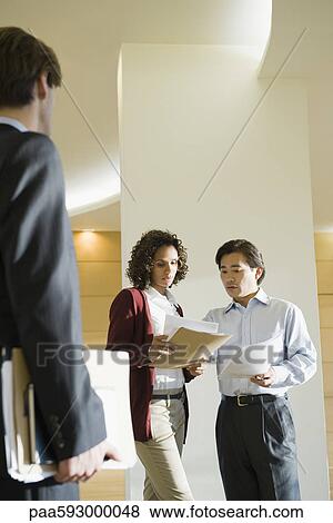 Executives discussing document View Large Photo Image Stock Photo - Executives discussing document. Fotosearch