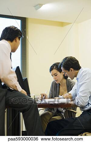 Executives discussing document View Large Photo Image Stock Photograph - Executives discussing document. Fotosearch