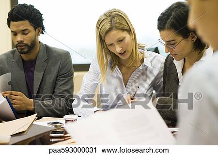 Executives discussing documents in meeting View Large Photo Image Stock Image - Executives discussing documents in meeting. Fotosearch