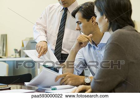 Executives looking at document together View Large Photo Image Stock Image - Executives looking at document together. Fotosearch