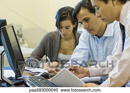 Executives working on project together View Large Photo Image Stock Image - Executives working on project together. Fotosearch