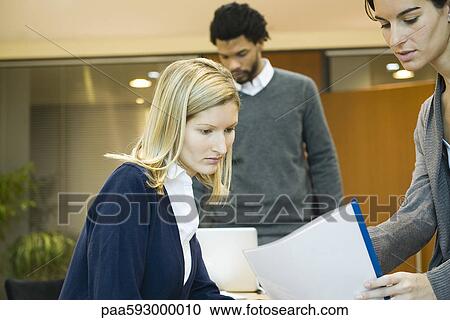 Female office worker showing document to colleague View Large Photo Image Stock Image - Female office worker showing document to colleague. Fotosearch