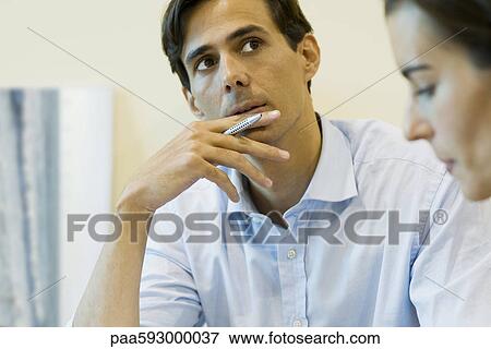 Man looking up in thought, pen in hand View Large Photo Image Stock Photo - Man looking up in thought, pen in hand. Fotosearch