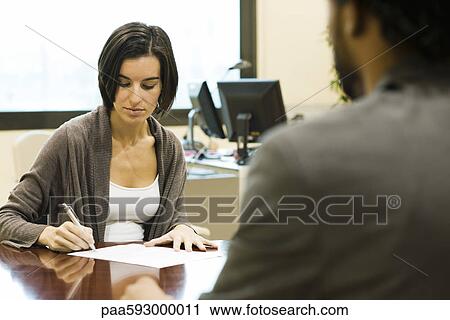 Woman signing document in office View Large Photo Image Stock Image - Woman signing document in office. Fotosearch