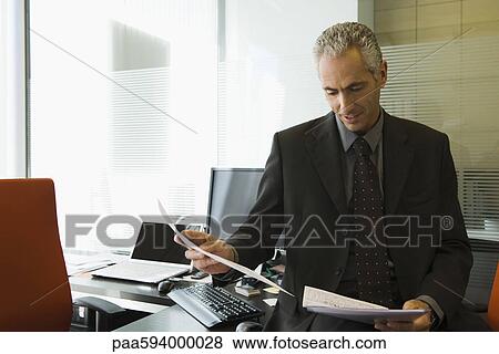 Executive reading report in office View Large Photo Image Stock Photo - Executive reading report in office. Fotosearch