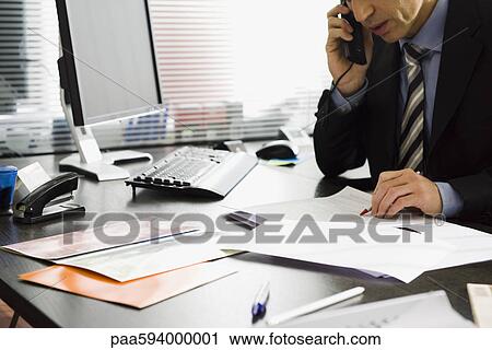 Executive talking on phone at desk View Large Photo Image Stock Image - Executive talking on phone at desk. Fotosearch