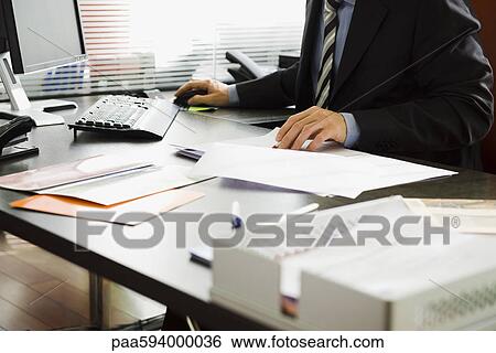 Executive working in office, cropped View Large Photo Image Stock Photograph - Executive working in office, cropped. Fotosearch