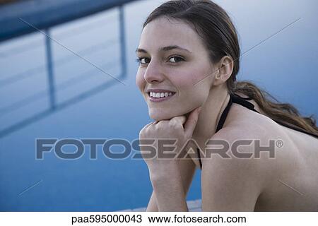 Stock Image - Woman beside pool, portrait. Fotosearch