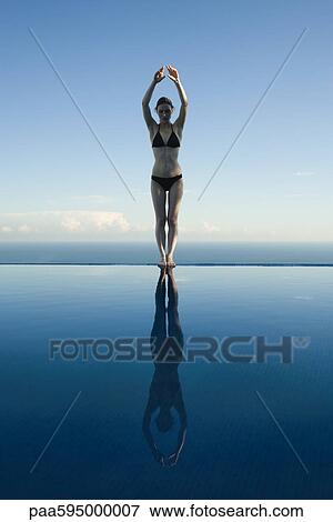 Stock Photo - Woman preparing to dive into pool. Fotosearch