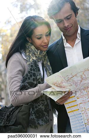 Stock Image - Couple consulting map outdoors. Fotosearch