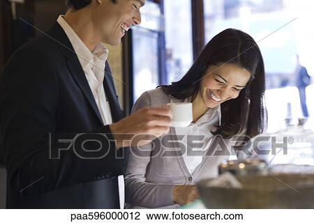 Couple laughing together in cafe View Large Photo Image Stock Image - Couple laughing together in cafe. Fotosearch