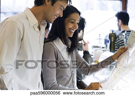 Couple looking at map together View Large Photo Image Stock Photograph - Couple looking at map together. Fotosearch
