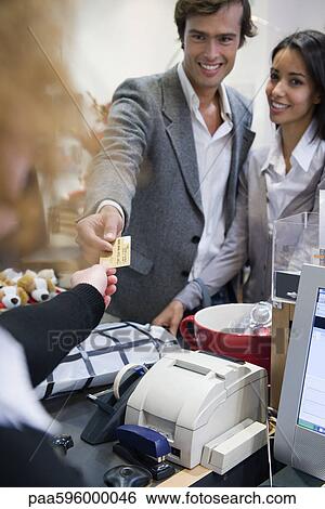 Stock Photograph - Couple paying for purchase with credit card. Fotosearch