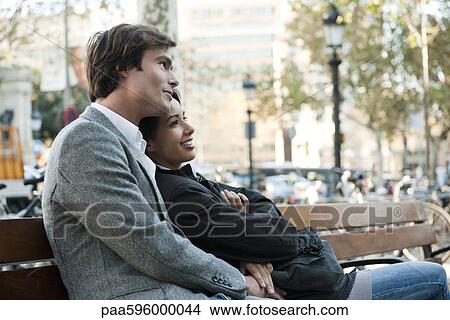 Couple relaxing on park bench View Large Photo Image Picture - Couple relaxing on park bench. Fotosearch