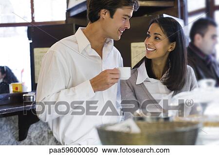 Stock Image - Couple relaxing together in cafe. Fotosearch