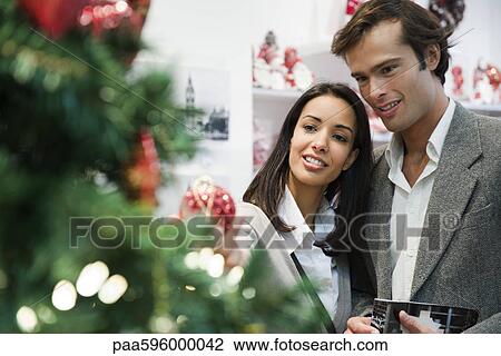 Stock Image - Couple shopping for Christmas decorations. Fotosearch
