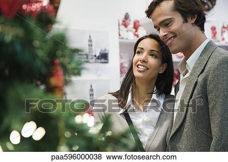 Couple shopping for Christmas decorations View Large Photo Image Stock Photo - Couple shopping for Christmas decorations. Fotosearch