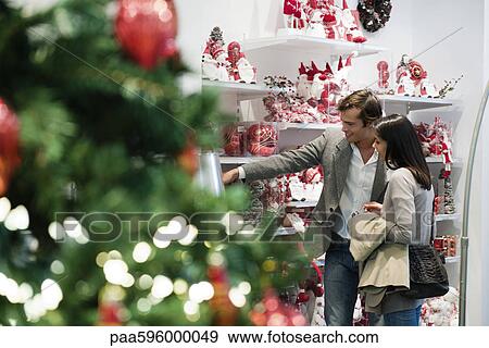 Couple shopping for Christmas decorations View Large Photo Image Stock Photo - Couple shopping for Christmas decorations. Fotosearch