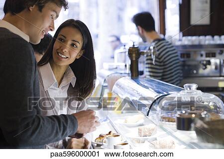 Stock Image - Couple talking together in cafe. Fotosearch
