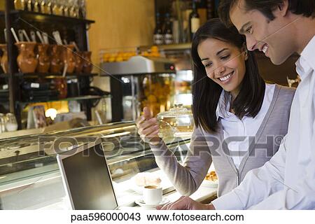 Couple using laptop computer in cafe View Large Photo Image Stock Image - Couple using laptop computer in cafe. Fotosearch