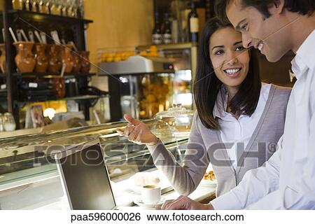 Couple using laptop computer in cafe View Large Photo Image Stock Photograph - Couple using laptop computer in cafe. Fotosearch