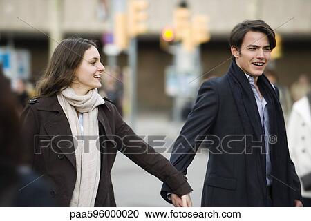 Stock Image - Couple walking hand in hand. Fotosearch