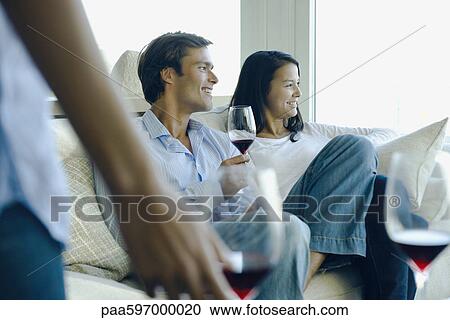Couple enjoying red wine on sofa View Large Photo Image Stock Image - Couple enjoying red wine on sofa. Fotosearch