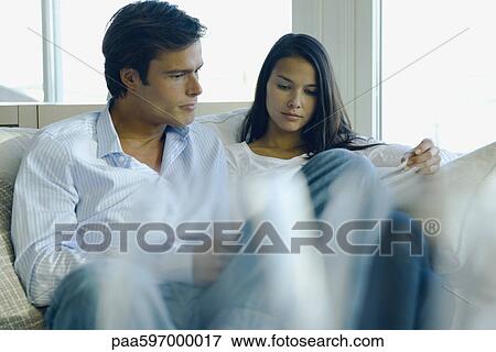 Stock Photo - Couple reading together on sofa. Fotosearch