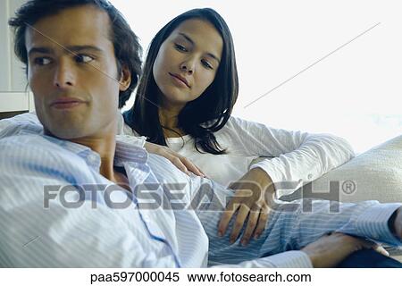 Couple relaxing together, woman caressing man's arm View Large Photo Image Stock Photography - Couple relaxing together, woman caressing man's arm. Fotosearch