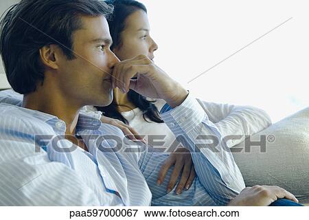 Couple sitting together, both looking away in thought View Large Photo Image Stock Photo - Couple sitting together, both looking away in thought. Fotosearch