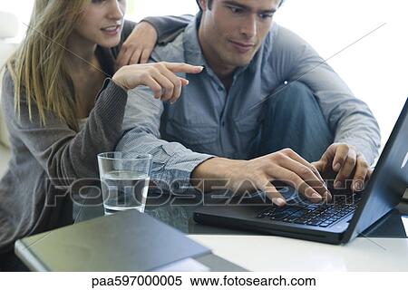 Stock Photography - Couple using laptop together. Fotosearch