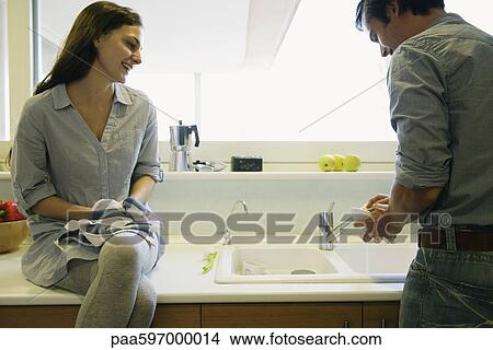 Couple washing dishes together View Large Photo Image Picture - Couple washing dishes together. Fotosearch
