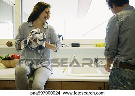 Couple washing dishes together View Large Photo Image Picture - Couple washing dishes together. Fotosearch