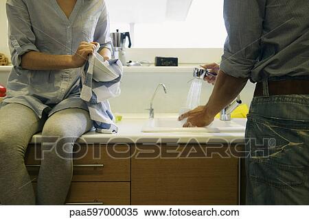 Couple washing dishes together View Large Photo Image Stock Photography - Couple washing dishes together. Fotosearch