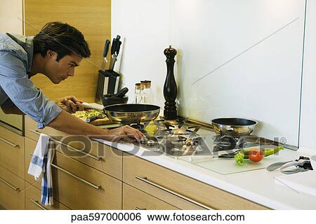 Man cooking on gas stovetop View Large Photo Image Stock Photograph - Man cooking on gas stovetop. Fotosearch